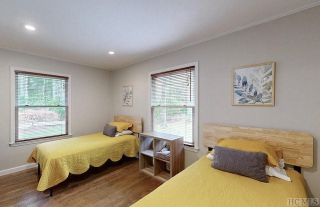 bedroom with crown molding, dark hardwood / wood-style flooring, and multiple windows