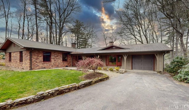 ranch-style house featuring a garage and a lawn