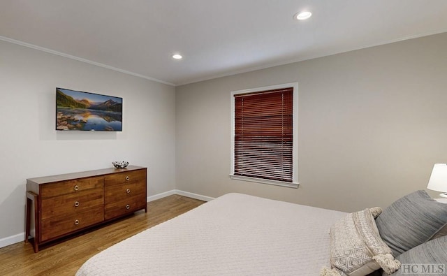 bedroom featuring crown molding and light hardwood / wood-style flooring