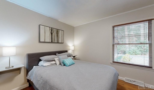 bedroom with crown molding and hardwood / wood-style flooring