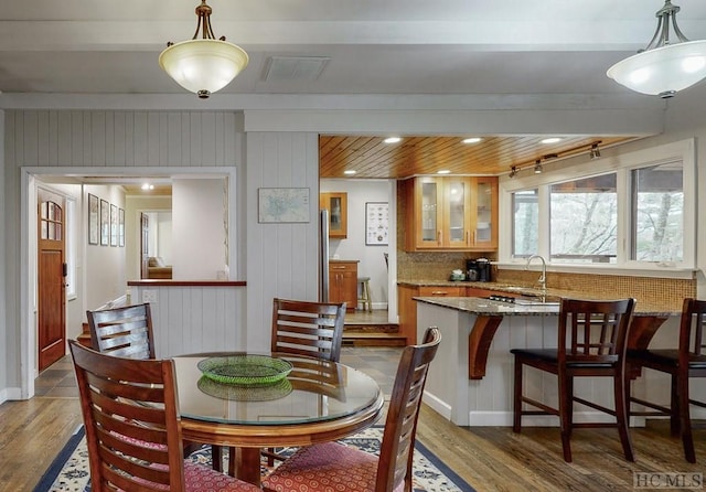 dining room with beamed ceiling, sink, hardwood / wood-style floors, and wood ceiling