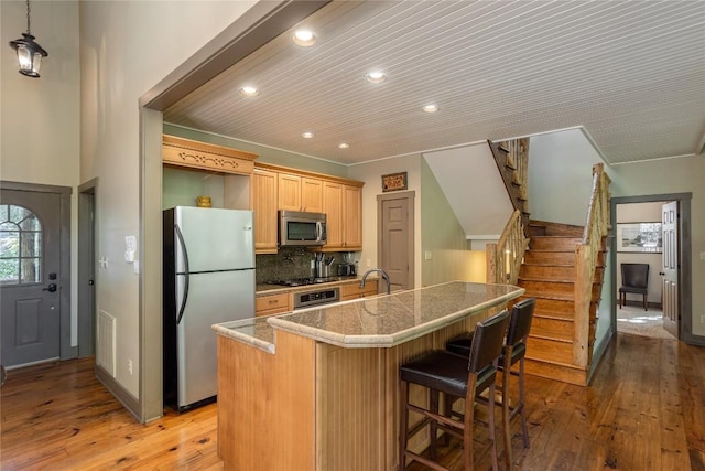 61 Indian Falls Way, Lake Toxaway, NC 28747 - kitchen featuring stainless steel appliances, tile countertops, recessed lighting, light wood finished floors, and a breakfast bar