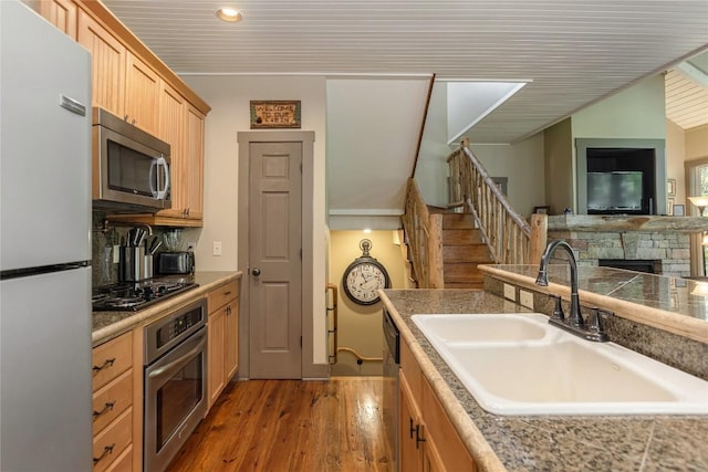 61 Indian Falls Way, Lake Toxaway, NC 28747 - kitchen with stainless steel appliances, wood finished floors, decorative backsplash, a stone fireplace, and recessed lighting