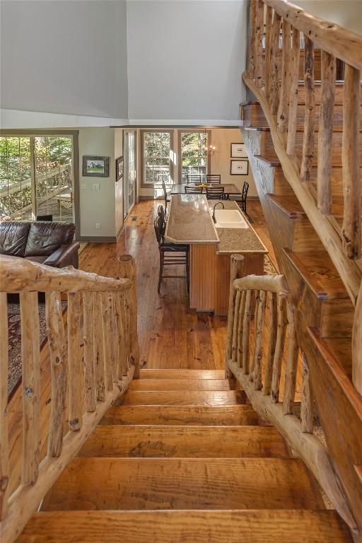 61 Indian Falls Way, Lake Toxaway, NC 28747 - staircase featuring high vaulted ceiling, hardwood / wood-style floors, and healthy amount of natural light