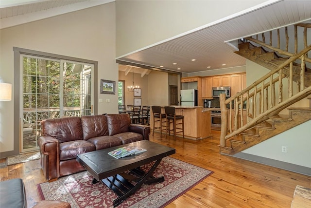 61 Indian Falls Way, Lake Toxaway, NC 28747 - living area with a chandelier, stairway, light wood-type flooring, high vaulted ceiling, and beamed ceiling