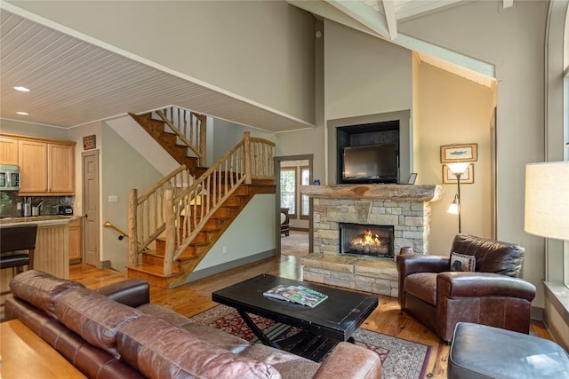 61 Indian Falls Way, Lake Toxaway, NC 28747 - living room with light wood-style floors, stairway, a stone fireplace, recessed lighting, and high vaulted ceiling