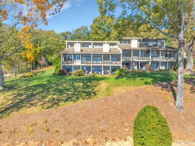 rear view of house featuring a lawn