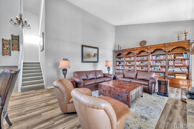 living room featuring an inviting chandelier, high vaulted ceiling, and light hardwood / wood-style flooring