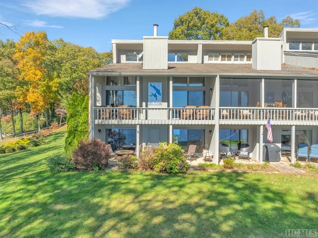 rear view of house featuring a patio and a yard