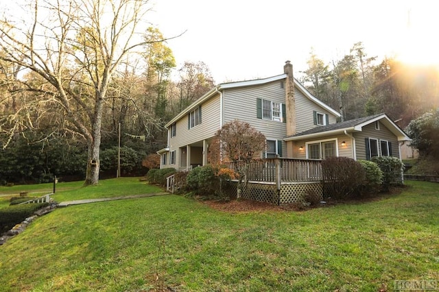 view of home's exterior featuring a wooden deck and a lawn