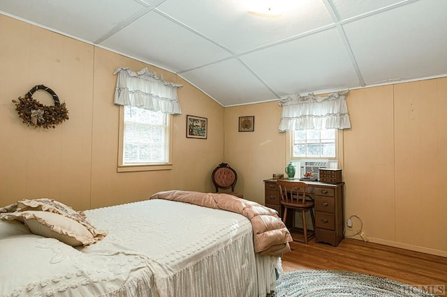 bedroom with multiple windows, cooling unit, and wood-type flooring