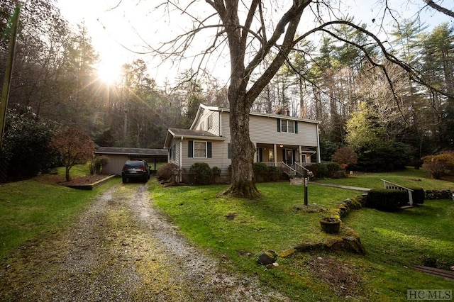 view of front of property with a carport, a porch, and a front yard