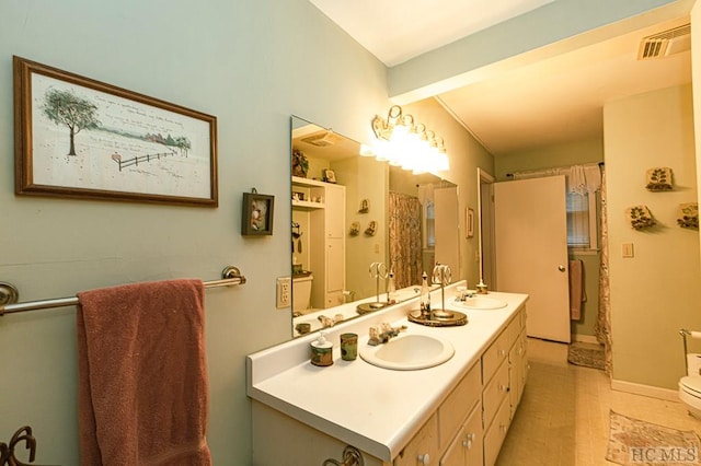 bathroom featuring vanity, beam ceiling, tile patterned floors, and toilet