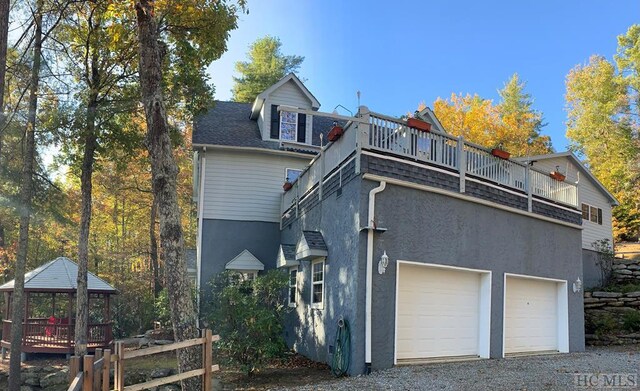 11 Lower Tanglewood Dr E, Lake Toxaway, NC 28747 - rear view of house with a gazebo, driveway, and stucco siding