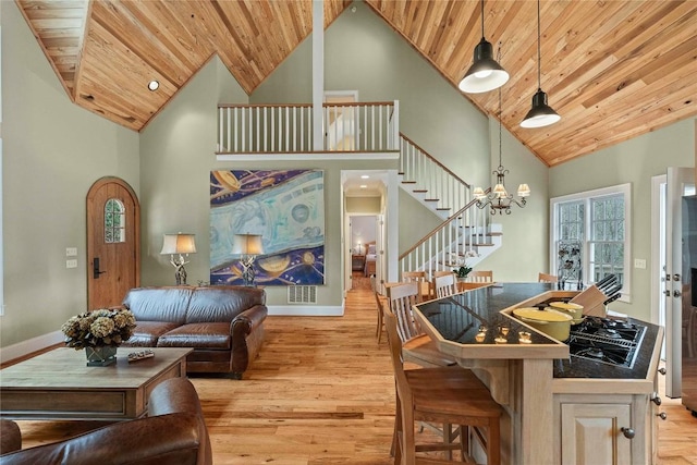 living area with a chandelier, stairs, wooden ceiling, light wood-style floors, and high vaulted ceiling