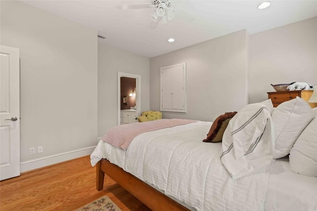 bedroom with visible vents, ensuite bath, wood finished floors, recessed lighting, and baseboards