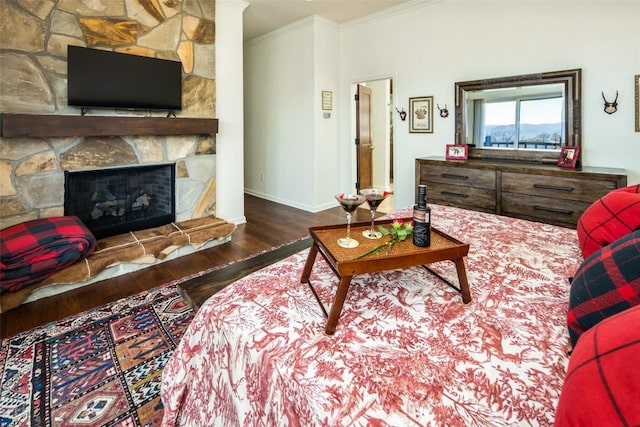 living room featuring wood finished floors, ornamental molding, baseboards, and a fireplace