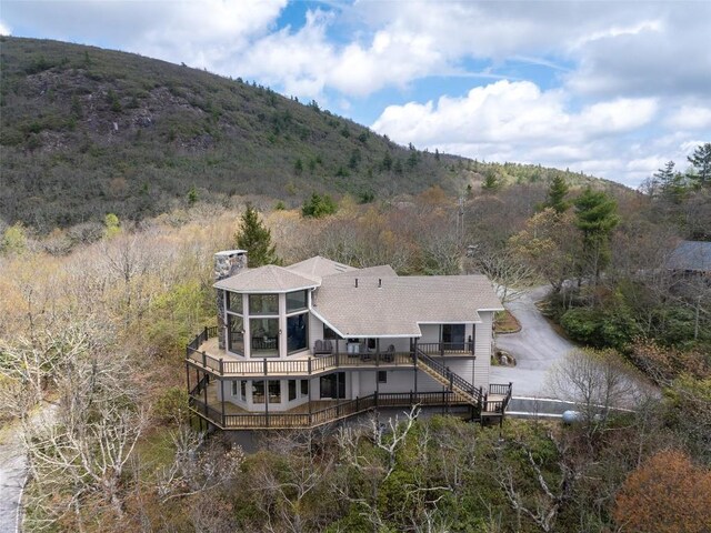 rear view of house with a chimney, stairway, and a deck with mountain view