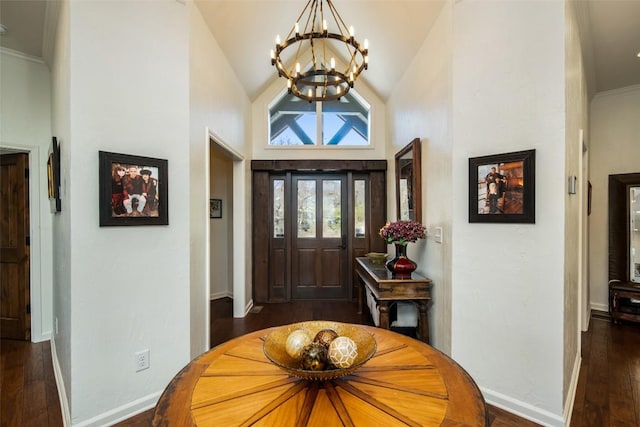 foyer with a chandelier, dark wood finished floors, baseboards, and high vaulted ceiling