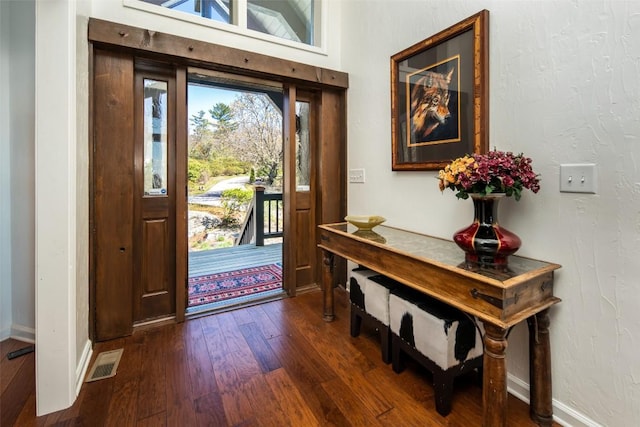 entrance foyer with dark wood-style floors and baseboards