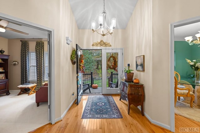 entrance foyer featuring an inviting chandelier, ornamental molding, and light wood-type flooring