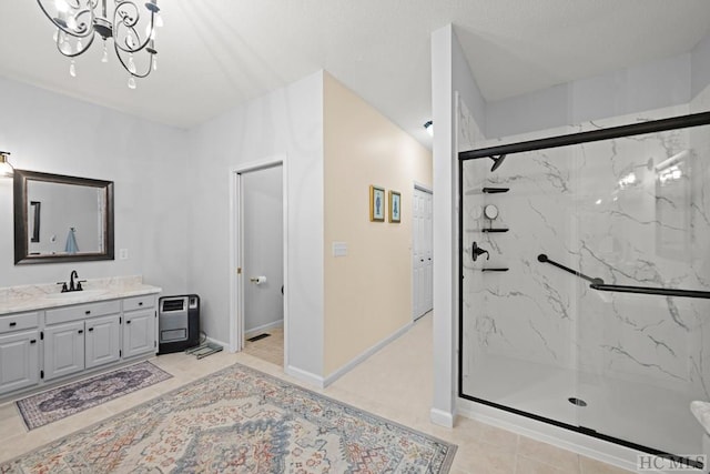 bathroom with vanity, tile patterned flooring, a shower with door, and an inviting chandelier