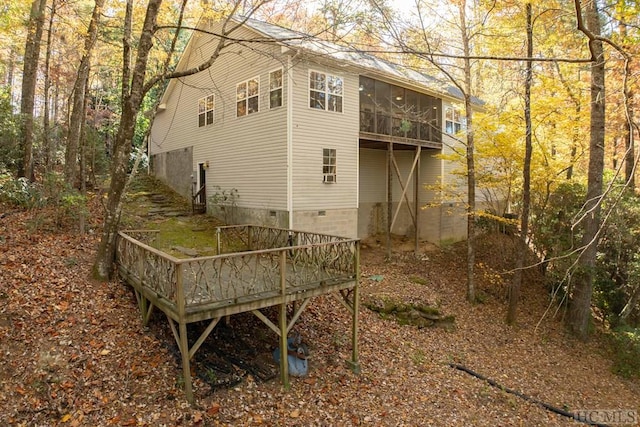 rear view of property featuring a sunroom and a wooden deck