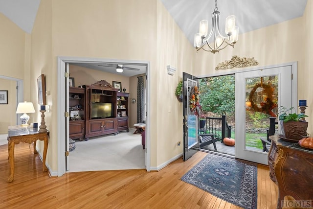 entrance foyer featuring a towering ceiling, a chandelier, light hardwood / wood-style floors, and a wealth of natural light