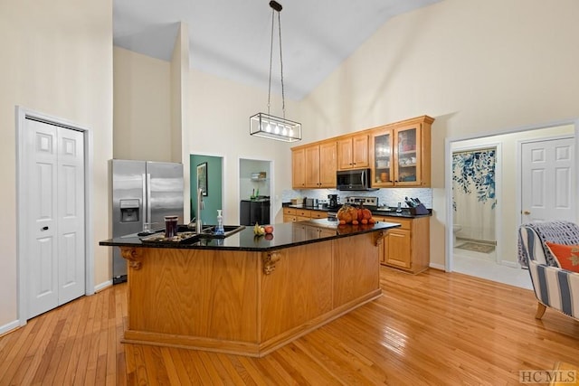 kitchen with stainless steel appliances, a center island, and high vaulted ceiling