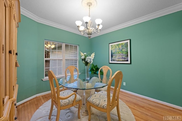 dining area featuring hardwood / wood-style flooring, ornamental molding, and a notable chandelier