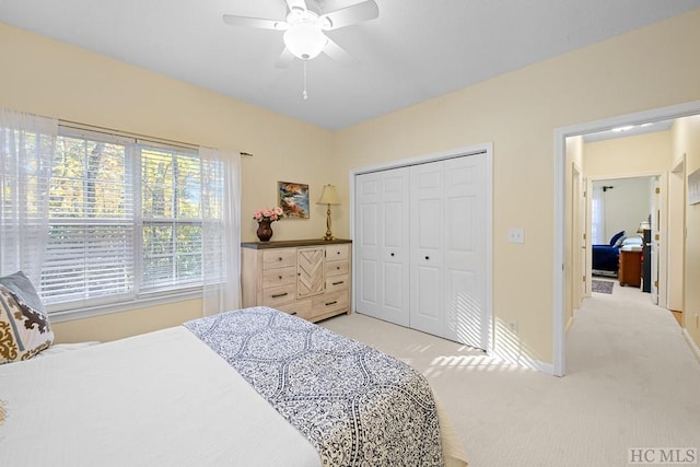 bedroom with light carpet, a closet, and ceiling fan