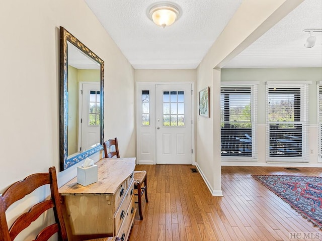 foyer featuring a textured ceiling and light hardwood / wood-style flooring