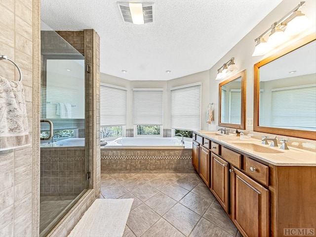 bathroom featuring vanity, a textured ceiling, and plus walk in shower