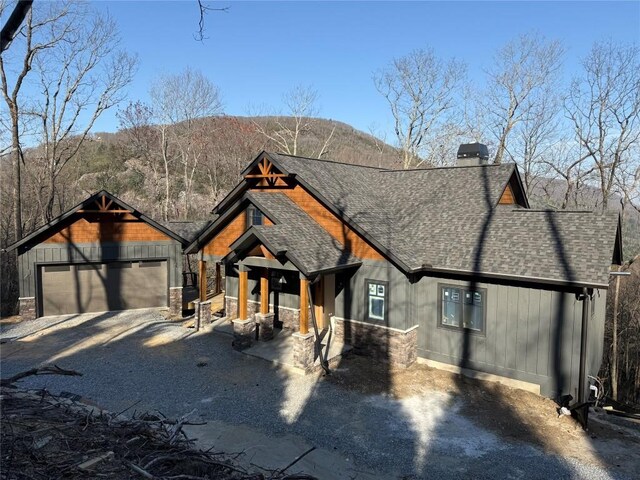 99 Sori Ln, Sapphire, NC 28774 - view of front facade featuring a shingled roof, a garage, a chimney, stone siding, and a mountain view