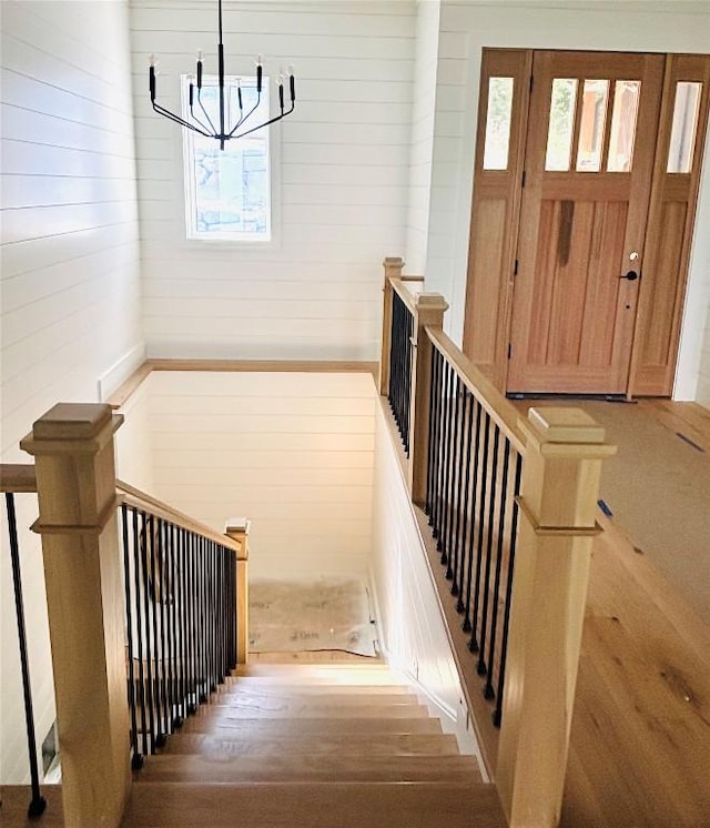 99 Sori Ln, Sapphire, NC 28774 - staircase featuring plenty of natural light, a chandelier, wood finished floors, and wood walls