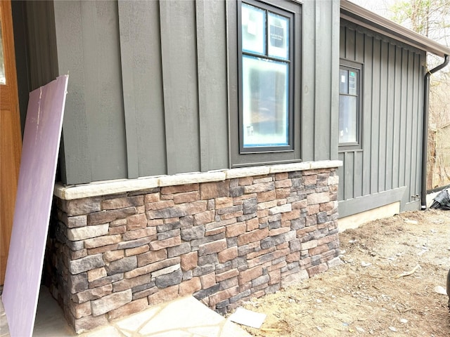 view of side of home featuring board and batten siding and stone siding