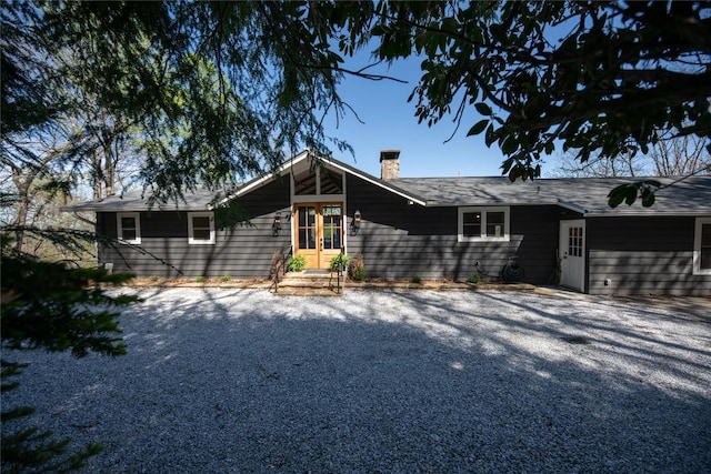 view of front facade featuring french doors and a chimney