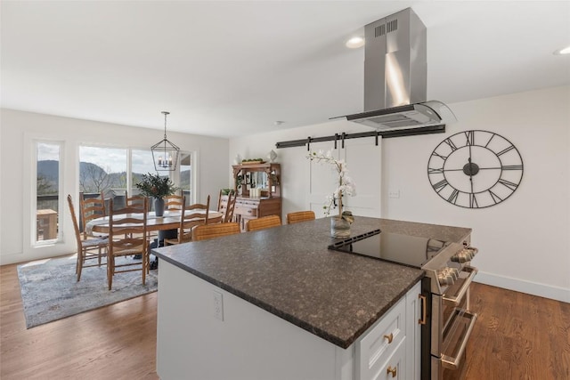 kitchen with a kitchen island, dark wood-style flooring, double oven range, island exhaust hood, and white cabinets