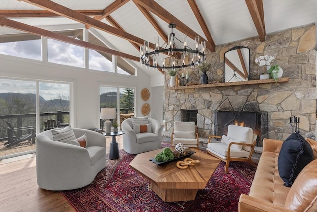 living area with a stone fireplace, wood finished floors, high vaulted ceiling, beamed ceiling, and a notable chandelier