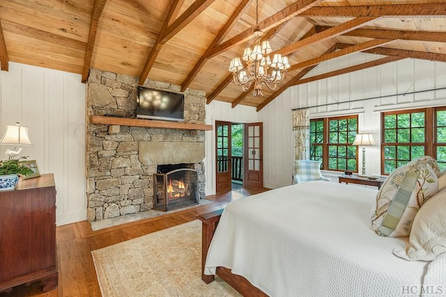 bedroom with wood ceiling, multiple windows, vaulted ceiling with beams, wood-type flooring, and a stone fireplace