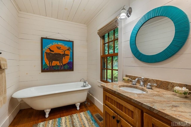 bathroom featuring wood ceiling, wooden walls, a bathing tub, a healthy amount of sunlight, and hardwood / wood-style floors