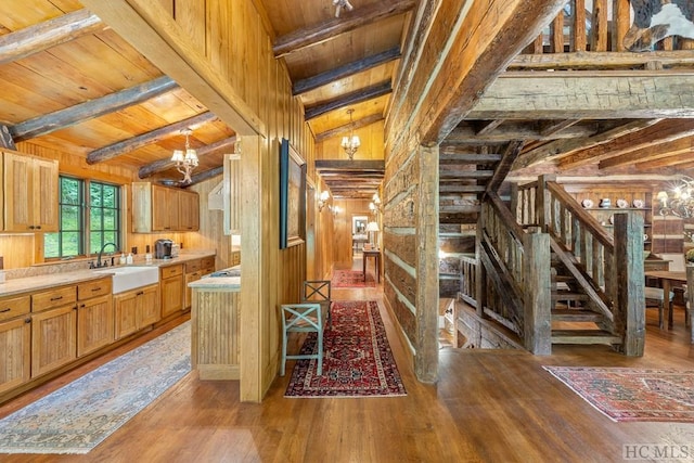 kitchen featuring a notable chandelier, wood ceiling, and wood walls