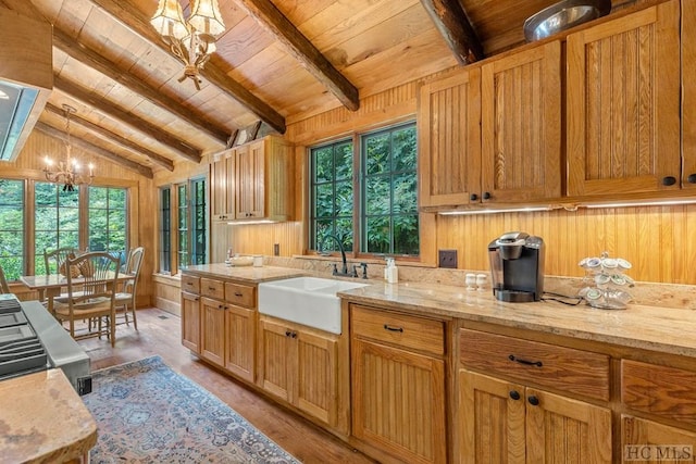 kitchen with lofted ceiling with beams, sink, hanging light fixtures, wood ceiling, and light hardwood / wood-style floors