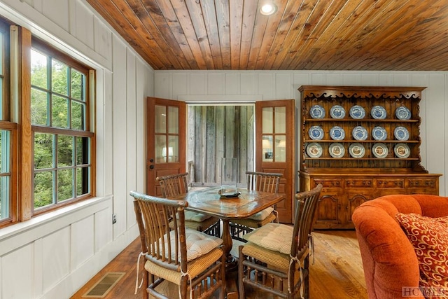 dining space featuring wood-type flooring and wooden ceiling