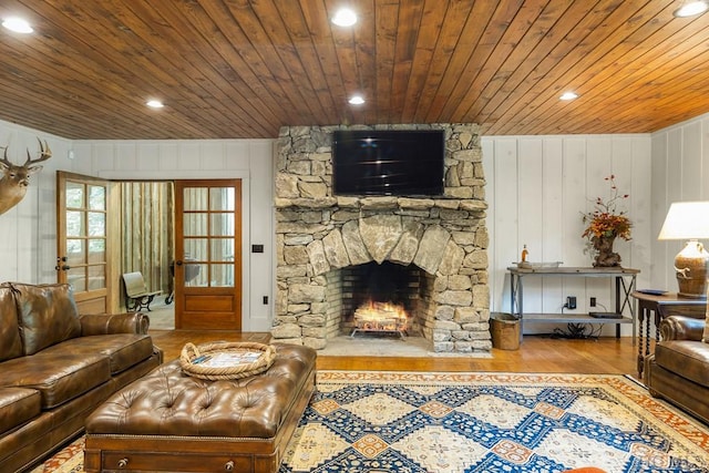 living room featuring hardwood / wood-style flooring, a fireplace, and wooden ceiling