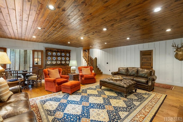 living room with wood ceiling, wooden walls, and light hardwood / wood-style flooring