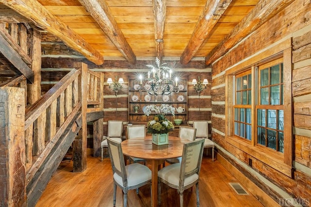 unfurnished dining area featuring beamed ceiling, wood ceiling, an inviting chandelier, and hardwood / wood-style floors