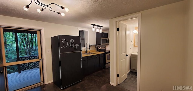 kitchen featuring stainless steel appliances, a textured ceiling, and sink