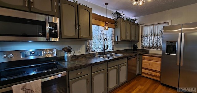 kitchen with sink, dark wood-type flooring, a textured ceiling, and stainless steel appliances