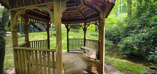 wooden terrace with a lawn and a gazebo